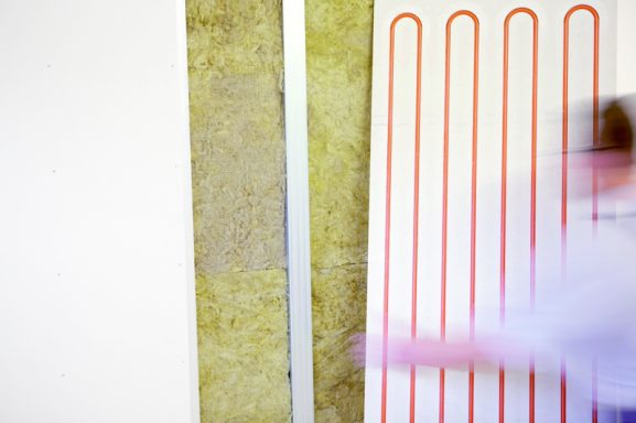 Graue Wand mit grüner Fläche und rot-gestreiftem Designelement, Bewegungsunschärfe.
